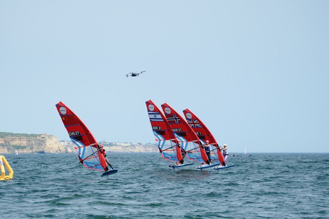A media drone filming iQFoil windsurfers at a mark in Portimão